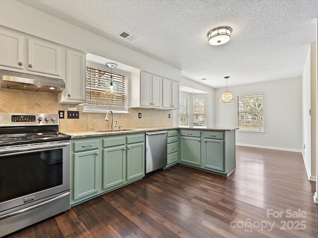 kitchen with decorative light fixtures, stainless steel appliances, visible vents, a sink, and under cabinet range hood