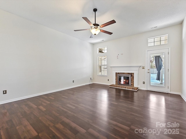 unfurnished living room featuring dark wood-style floors, plenty of natural light, and visible vents