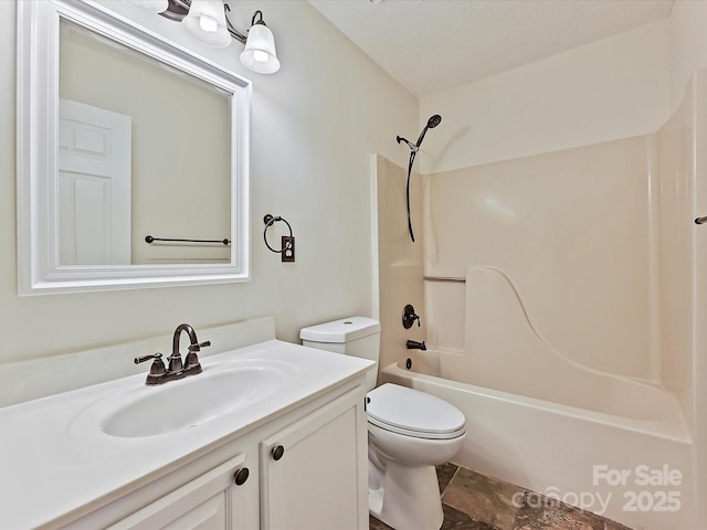 bathroom featuring toilet, vanity, a textured ceiling, and shower / bathing tub combination