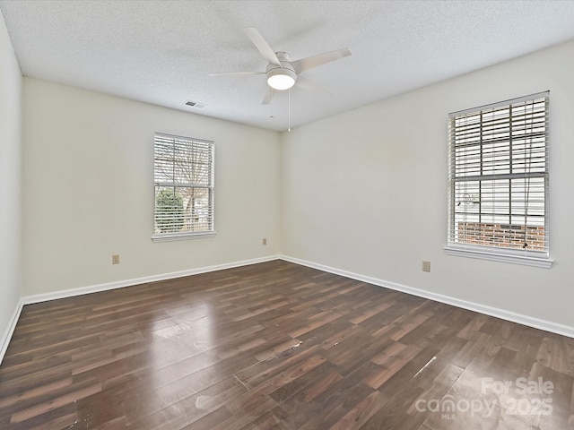 empty room featuring ceiling fan, baseboards, dark wood finished floors, and a textured ceiling