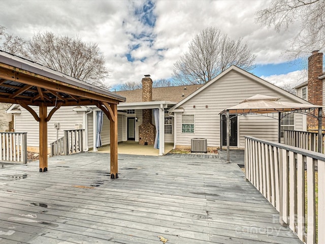 wooden deck with a gazebo and central AC unit