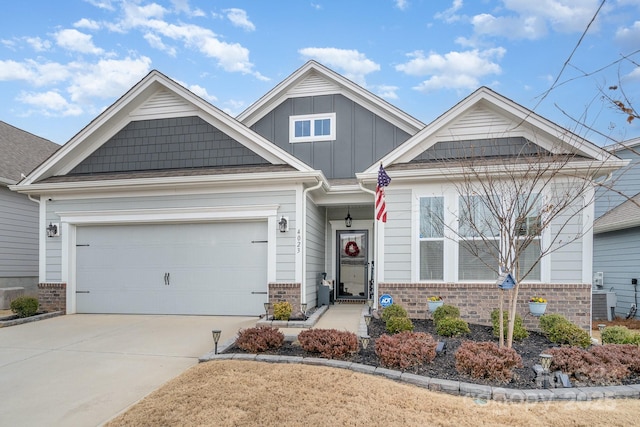 craftsman inspired home featuring driveway, an attached garage, board and batten siding, and brick siding