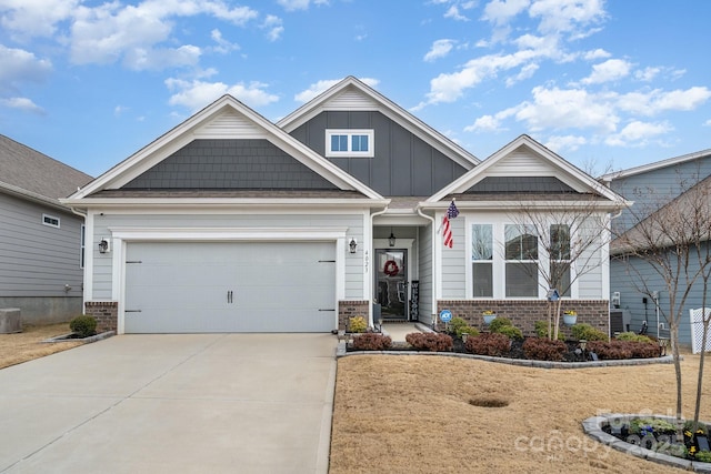 craftsman-style house featuring an attached garage, concrete driveway, board and batten siding, and brick siding