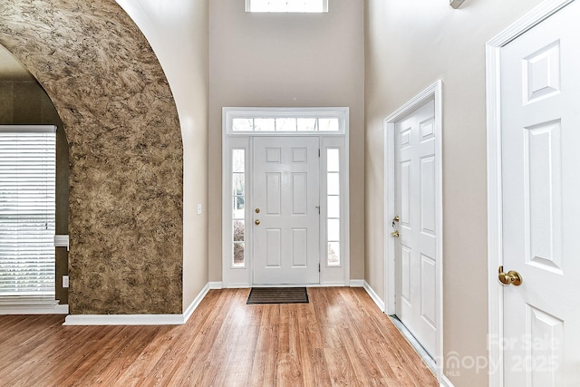 entryway featuring a high ceiling and light hardwood / wood-style floors