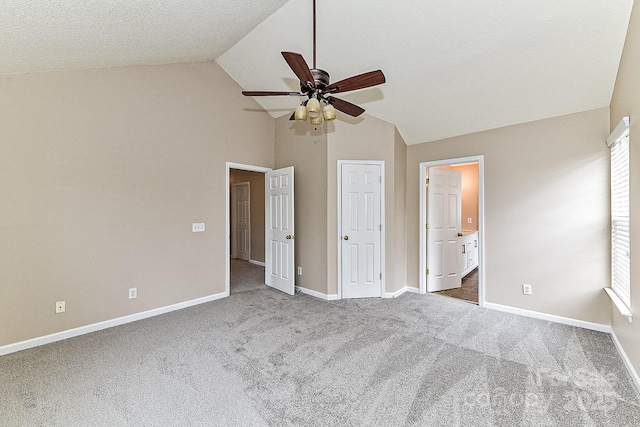 unfurnished bedroom featuring vaulted ceiling, carpet floors, and connected bathroom