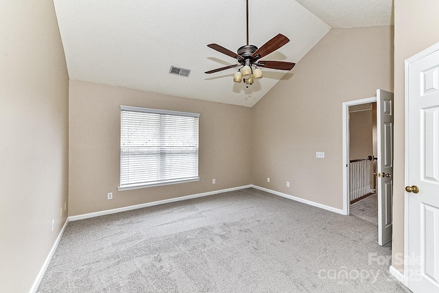 unfurnished room with a textured ceiling, vaulted ceiling, light colored carpet, and ceiling fan