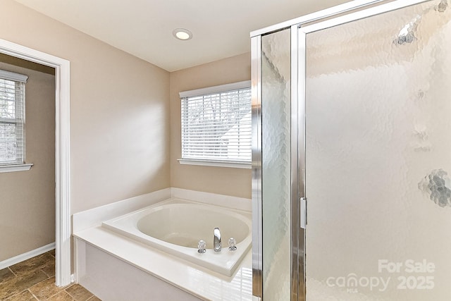 bathroom with plenty of natural light and separate shower and tub