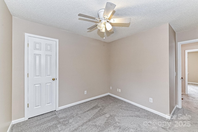 carpeted empty room featuring a textured ceiling and ceiling fan