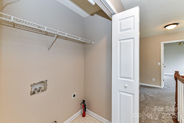 washroom featuring hookup for a washing machine, hookup for an electric dryer, light colored carpet, and a textured ceiling