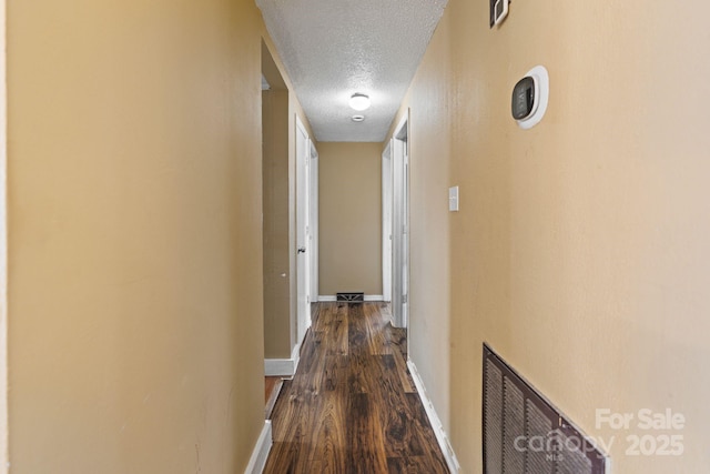 hallway featuring a textured ceiling and wood-type flooring