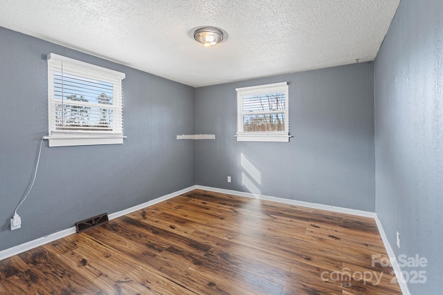 spare room with wood-type flooring and a textured ceiling