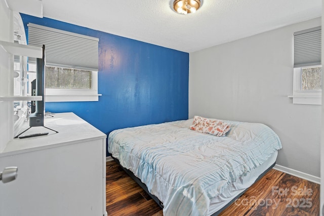 bedroom with dark wood-type flooring and a textured ceiling