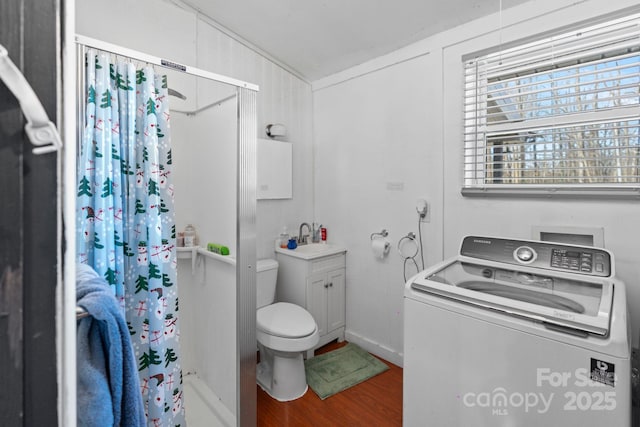 bathroom with hardwood / wood-style flooring, washer / dryer, vanity, and toilet