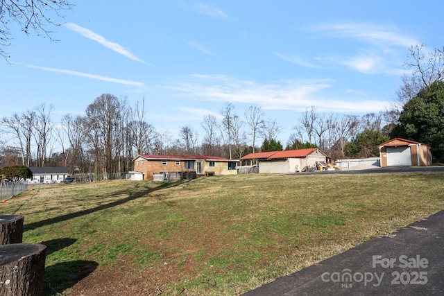 view of front of home featuring a garage, a front yard, and an outdoor structure