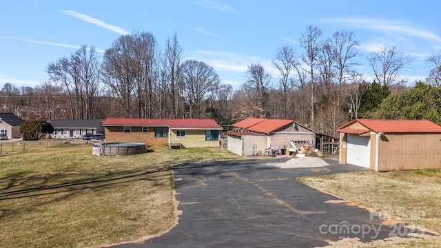 view of front of home featuring an outbuilding, a garage, and a front lawn