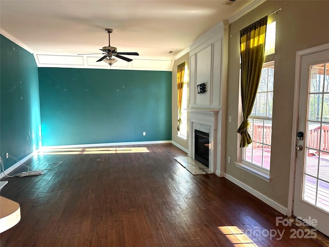 unfurnished living room with ceiling fan, ornamental molding, a high end fireplace, and dark hardwood / wood-style flooring