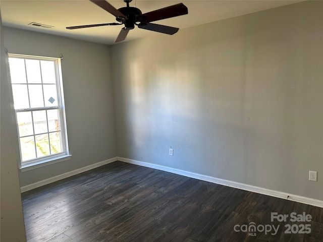 empty room with dark hardwood / wood-style floors and ceiling fan