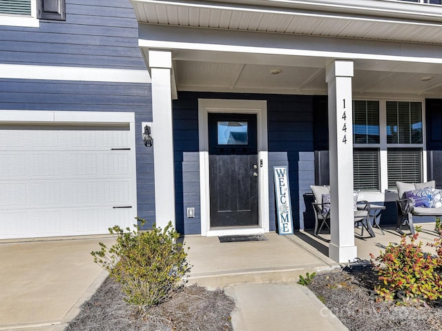 view of exterior entry with covered porch and a garage