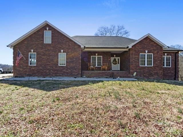 back of property with a lawn and brick siding