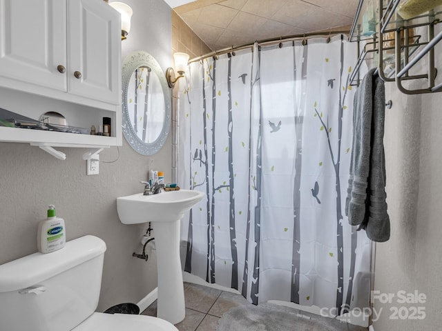 bathroom featuring a shower with curtain, tile patterned floors, and toilet