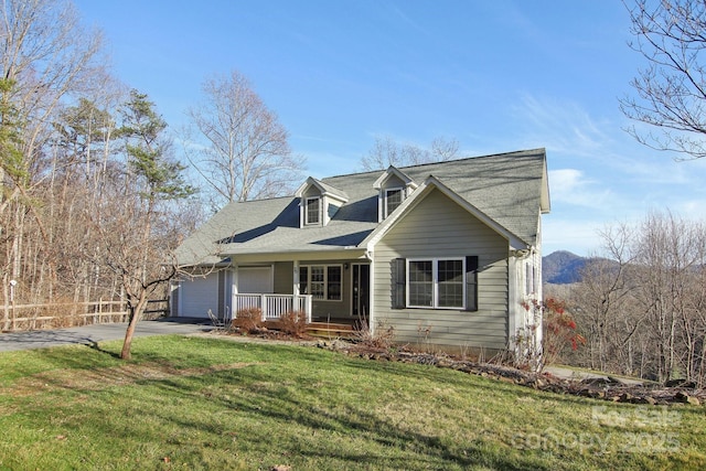 view of front of home with covered porch, a front yard, and a garage