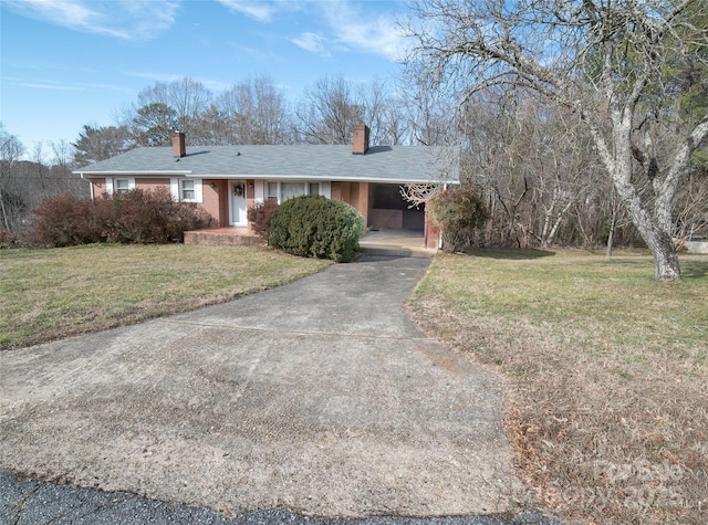 ranch-style house with an attached carport, concrete driveway, brick siding, and a front lawn