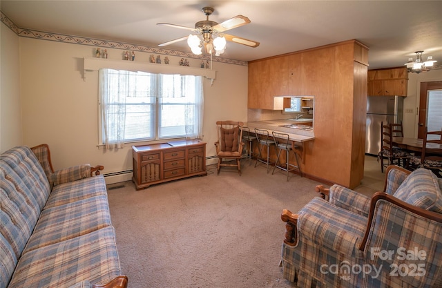 interior space featuring a ceiling fan, light colored carpet, and baseboard heating