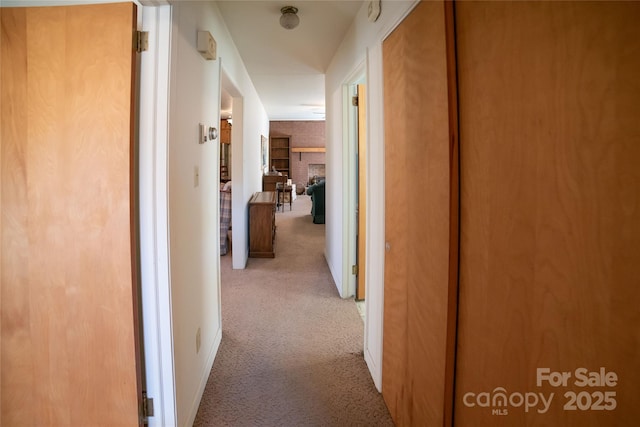 corridor featuring baseboards and carpet floors