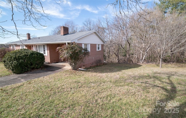 view of property exterior with a lawn, brick siding, and a chimney