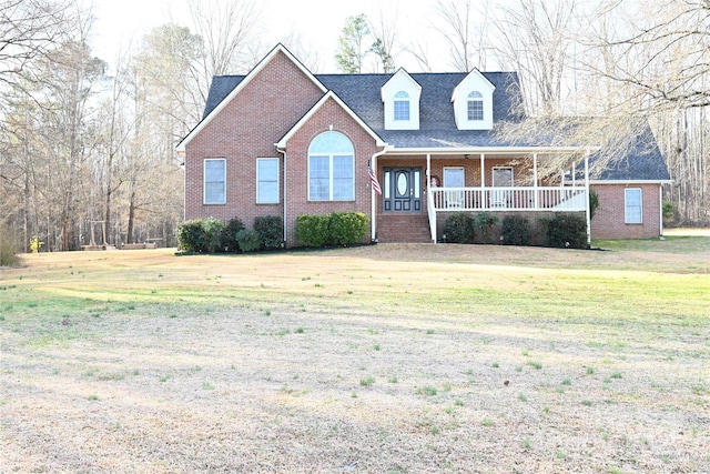 cape cod-style house featuring a front yard and covered porch