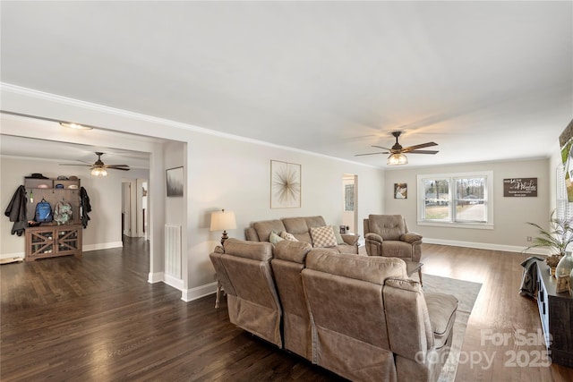 living area with ceiling fan, baseboards, dark wood finished floors, and ornamental molding