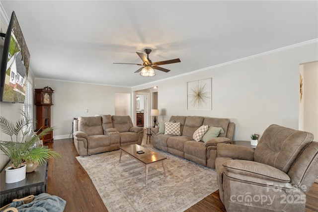 living area with baseboards, dark wood finished floors, a ceiling fan, and ornamental molding