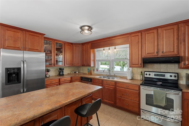 kitchen with tasteful backsplash, under cabinet range hood, a kitchen breakfast bar, stainless steel appliances, and a sink