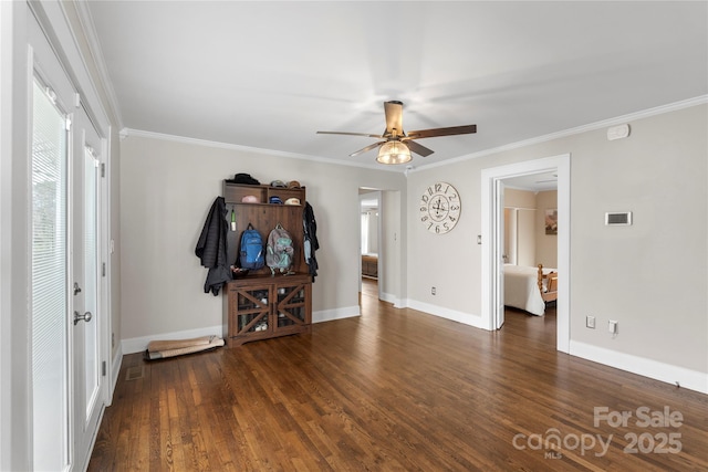 interior space with baseboards, a ceiling fan, wood finished floors, and crown molding