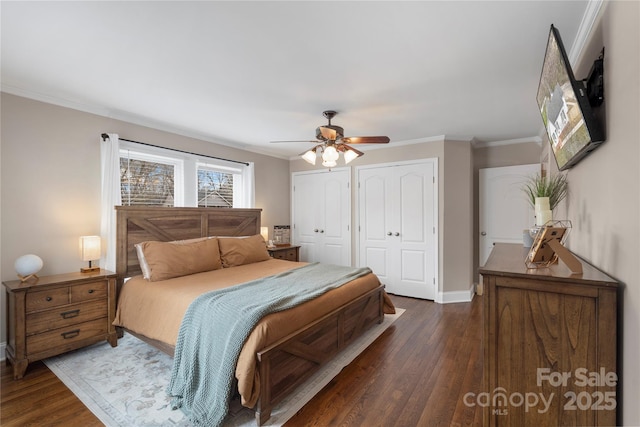 bedroom with ceiling fan, baseboards, multiple closets, ornamental molding, and dark wood-style flooring