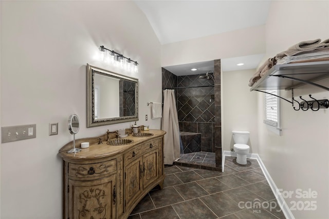 bathroom with a sink, toilet, tile patterned flooring, and tiled shower