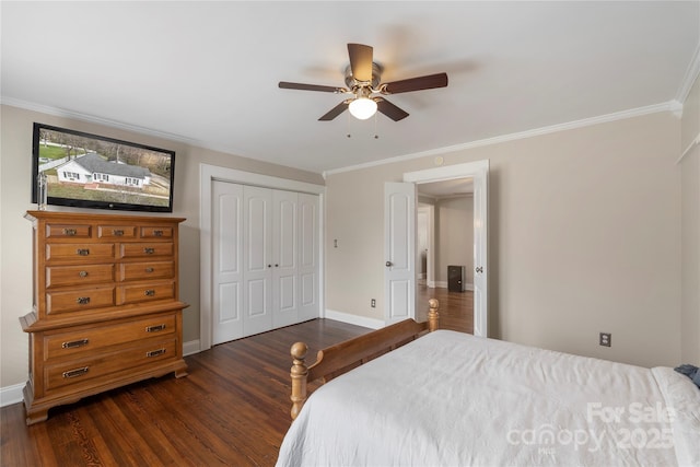 bedroom featuring ornamental molding, a ceiling fan, dark wood-style floors, a closet, and baseboards