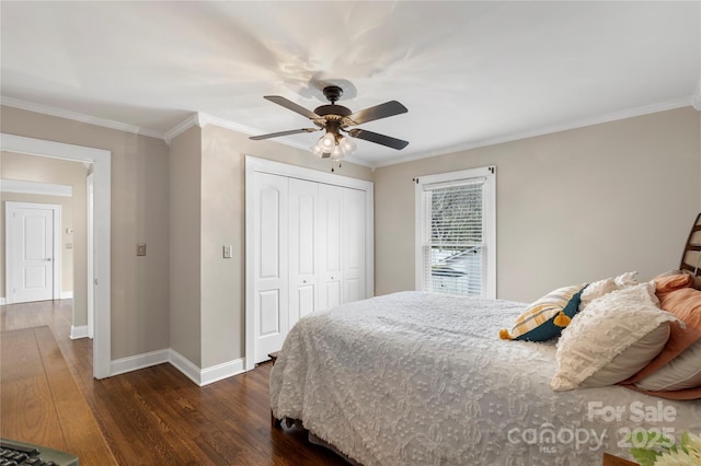 bedroom featuring crown molding, baseboards, a closet, and dark wood-style flooring