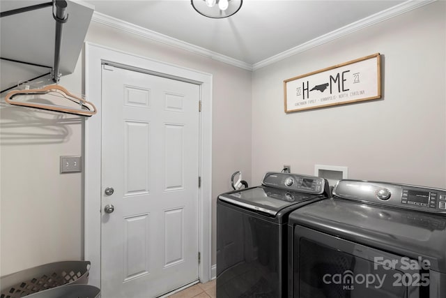 laundry room featuring light tile patterned flooring, ornamental molding, laundry area, and washer and clothes dryer