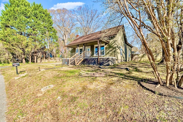 exterior space featuring a front lawn, a chimney, and a porch