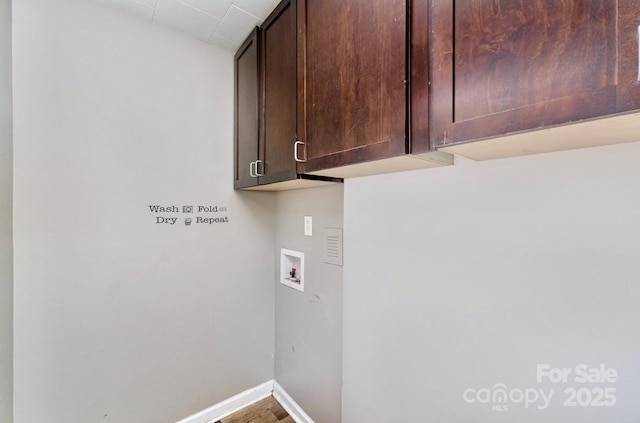 laundry area featuring wood finished floors, cabinet space, baseboards, and washer hookup