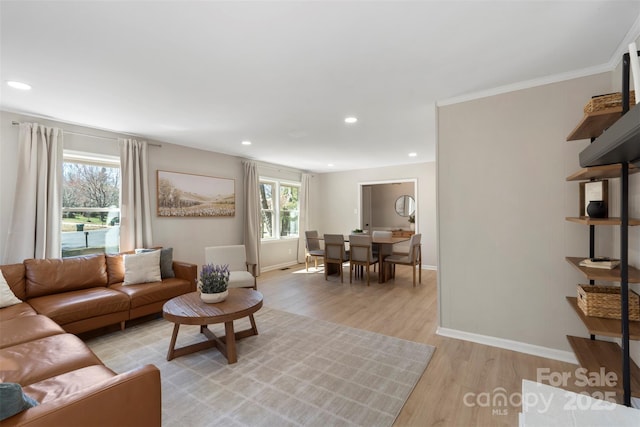 living room with light wood-style floors, baseboards, crown molding, and recessed lighting