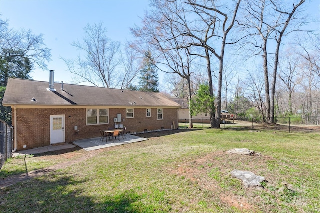 back of property with a lawn, crawl space, fence, a patio area, and brick siding