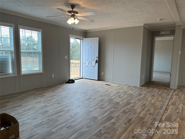 empty room with wood-type flooring, ceiling fan, and a textured ceiling