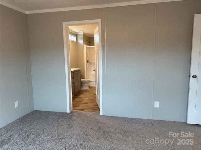 unfurnished bedroom with light carpet and crown molding