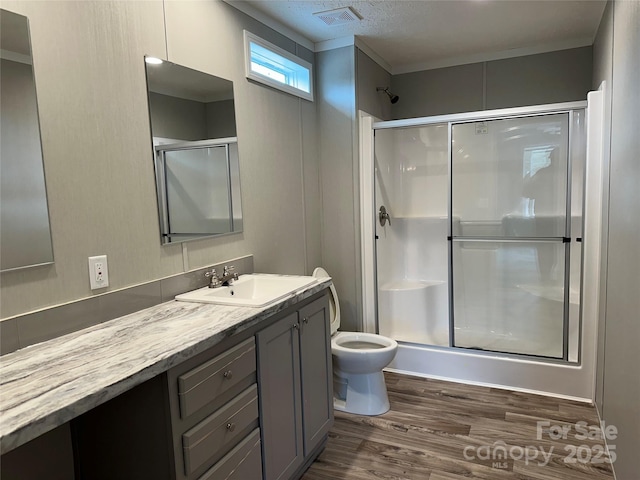 bathroom with vanity, hardwood / wood-style floors, a shower with door, and toilet