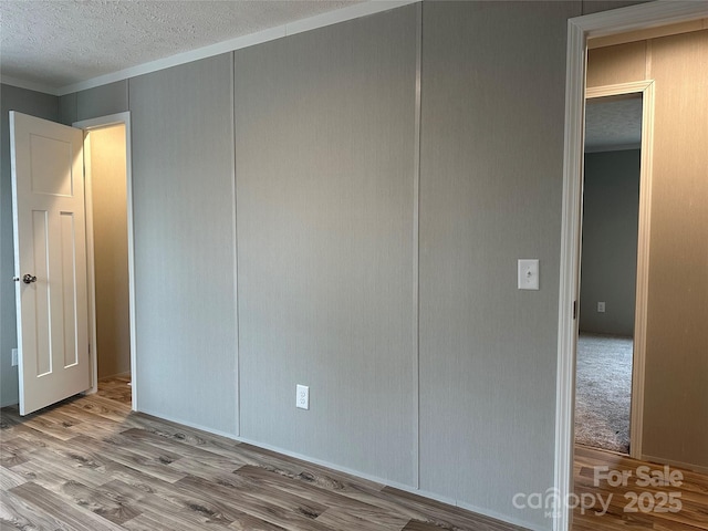 unfurnished bedroom featuring a closet, light hardwood / wood-style floors, and a textured ceiling