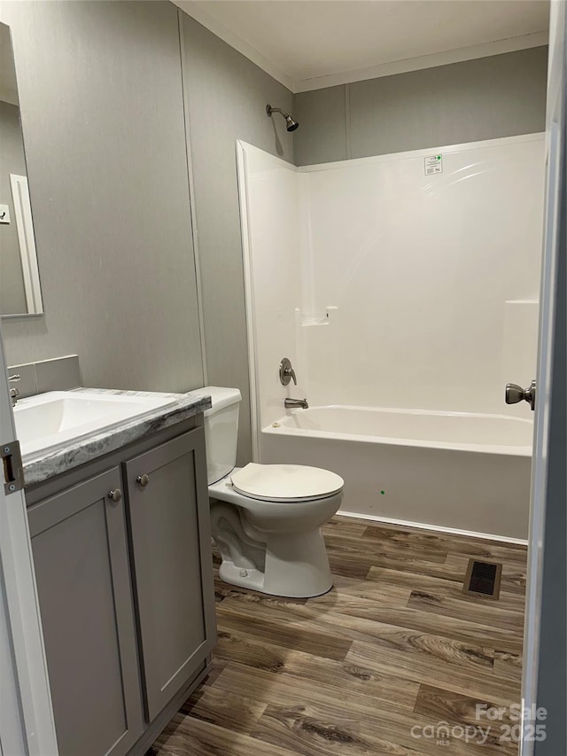 full bathroom with vanity, hardwood / wood-style flooring, bathtub / shower combination, and toilet