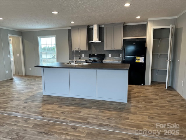 kitchen with sink, gray cabinetry, black appliances, dark hardwood / wood-style flooring, and wall chimney exhaust hood