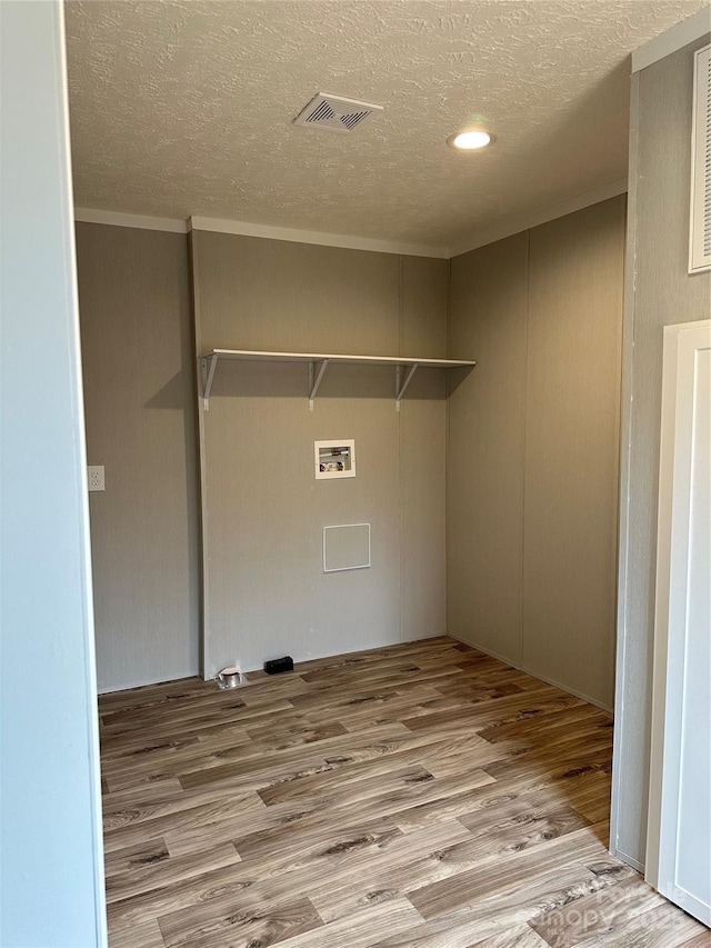 laundry area featuring washer hookup, a textured ceiling, and light hardwood / wood-style flooring